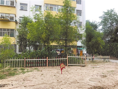 9號(hào)樓前小區(qū)綠地空置，被居民圍起柵欄圈占種菜。 本報(bào)記者    張艷麗    攝