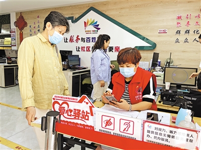 8月31日，社區(qū)工作人員幫助老年居民在手機上辦理業(yè)務(wù)。      本報記者 毛雪皎 攝