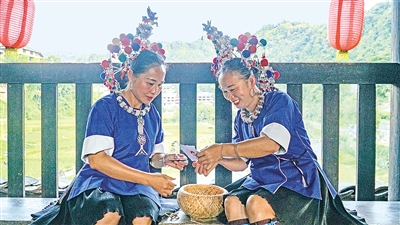     程陽橋上，侗族婦女在展示制作侗族刺繡產(chǎn)品。繡品圖案精美、色彩艷麗，成為當?shù)靥厣a(chǎn)業(yè)。